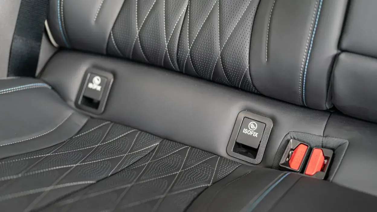 Banco traseiro de carro com sistema ISOFIX para cadeiras infantis e cintos de segurança visíveis.